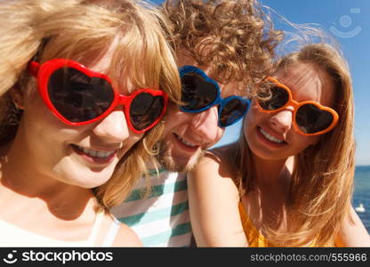 Friendship happiness summer holidays concept. Group of friends boy two girls in colorful sunglasses having fun outdoor, joy playful mood.. Group friends boy two girls having fun outdoor