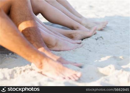 friendship, happiness, summer vacation, holidays and people concept - close up of friends sitting beach