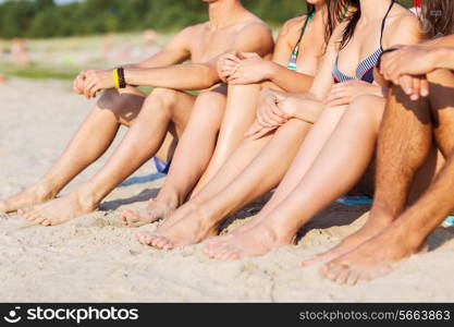 friendship, happiness, summer vacation, holidays and people concept - close up of friends sitting beach