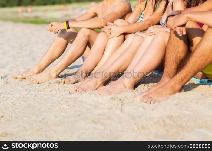 friendship, happiness, summer vacation, holidays and people concept - close up of friends sitting beach