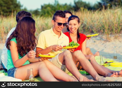 friendship, happiness, summer vacation, holidays and people concept - group of smiling friends sitting beach