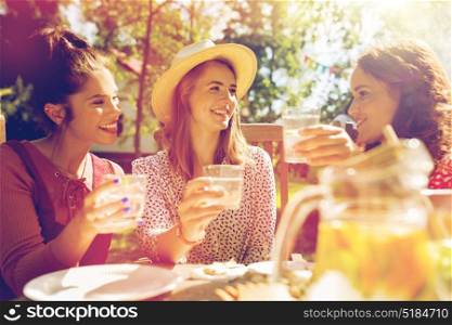 friendship, holidays, celebration, people and food concept - happy women or friends having party at summer garden. happy friends having party at summer garden