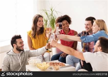 friendship, holidays, fast food and celebration concept - happy friends having party and clinking drinks at home. friends having party and clinking drinks at home