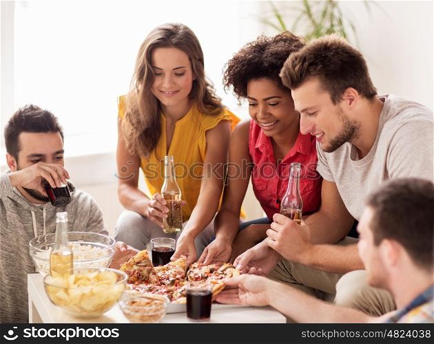 friendship, holidays, fast food and celebration concept - happy friends with drinks and snacks eating pizza at home