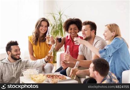 friendship, holidays, fast food and celebration concept - happy friends with drinks and snacks having party at home