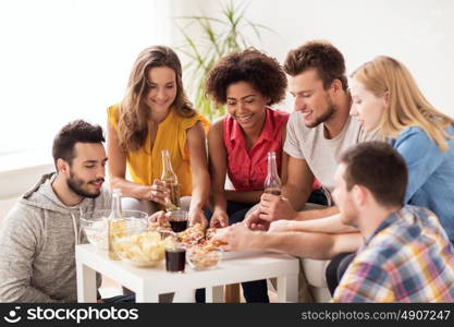 friendship, holidays, fast food and celebration concept - happy friends with drinks and snacks eating pizza at home. happy friends with drinks eating pizza at home