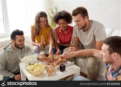 friendship, holidays, fast food and celebration concept - happy friends with drinks and snacks eating pizza at home. happy friends with drinks eating pizza at home