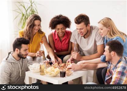 friendship, holidays, fast food and celebration concept - happy friends with drinks and snacks eating pizza at home. happy friends with drinks eating pizza at home