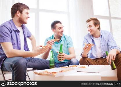 friendship, home, drinks and food concept - happy male friends with beer and pizza at home
