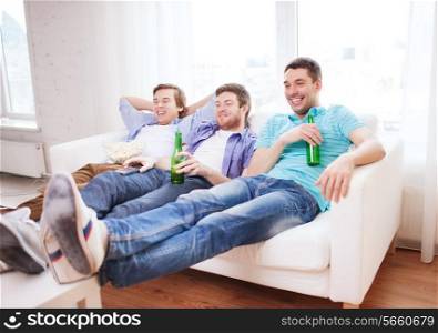 friendship, home, sports and entertainment concept - happy male friends with beer watching tv at home