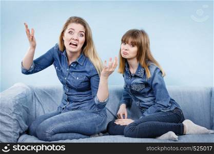 Friendship, human relations concept. Two crazy women friends or sisters wearing jeans shirts having weird conversation, yelling.. Two women friends having weird conversation
