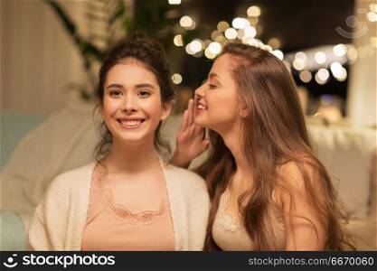 friendship, hygge and pajama party concept - happy female friends or teenage girls gossiping at home. happy female friends gossiping at home. happy female friends gossiping at home