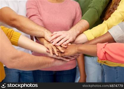 friendship, international, teamwork and people concept - close up of hands on top of each other