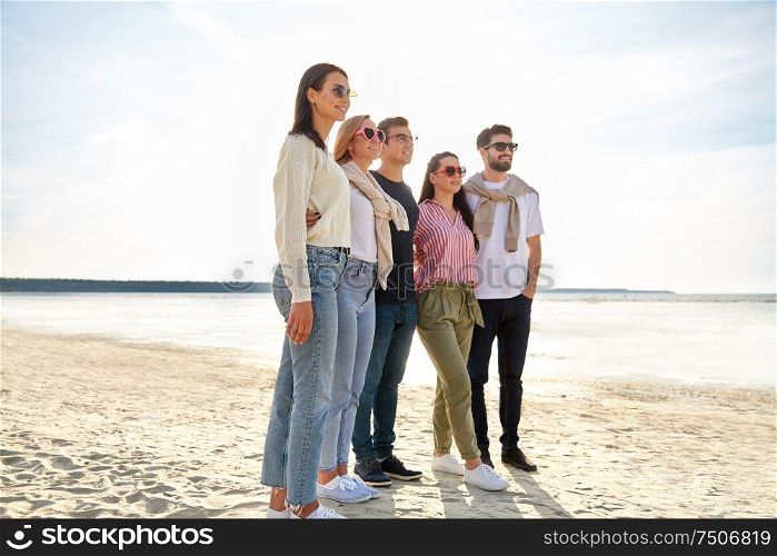 friendship, leisure and people concept - group of happy friends on beach in summer. happy friends on summer beach