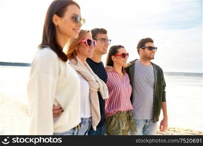 friendship, leisure and people concept - group of happy friends on beach in summer. happy friends on summer beach
