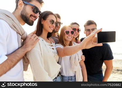 friendship, leisure and people concept - group of happy friends taking selfie by smartphone in summer. happy friends taking selfie in summer