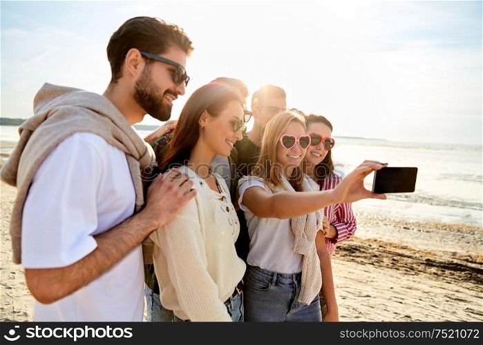 friendship, leisure and people concept - group of happy friends taking selfie by smartphone in summer. happy friends taking selfie in summer