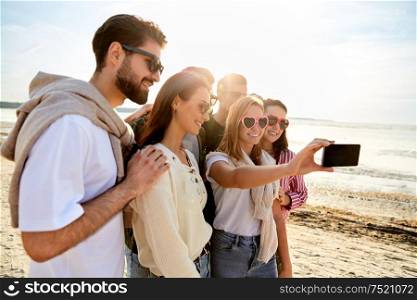 friendship, leisure and people concept - group of happy friends taking selfie by smartphone in summer. happy friends taking selfie in summer