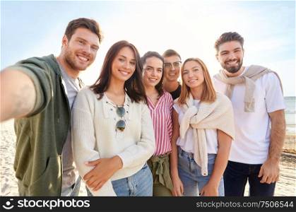 friendship, leisure and people concept - group of happy friends taking selfie on beach in summer. happy friends taking selfie on summer beach
