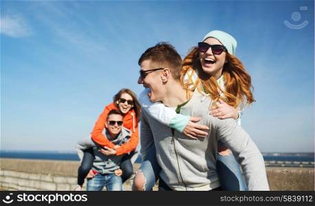 friendship, leisure and people concept - group of happy teenage friends in sunglasses having fun outdoors