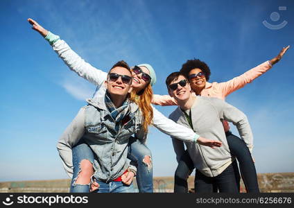 friendship, leisure and people concept - group of happy teenage friends in sunglasses having fun outdoors