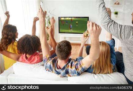 friendship, leisure and people concept - happy friends with non-alcoholic beer sitting on sofa and watching soccer or football game on tv at home. friends with beer watching soccer on tv at home