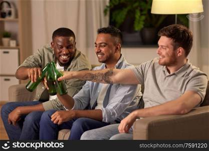 friendship, leisure and people concept - happy male friends drinking beer at home at night. happy male friends drinking beer at home at night