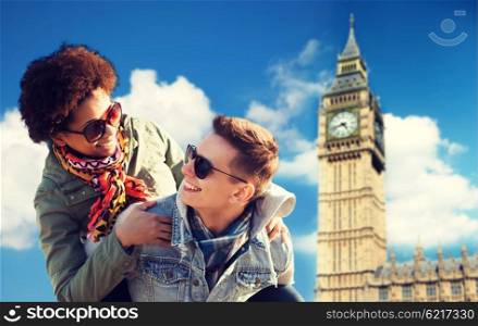 friendship, leisure, international, freedom and people concept - happy teenage couple in shades having fun over london big ben tower background