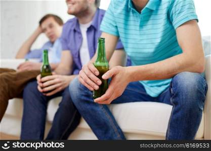 friendship, leisure, people and alcohol concept - close up of happy male friends drinking beer at home