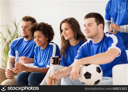 friendship, leisure, sport and entertainment concept - happy friends or football fans with drinks watching soccer at home