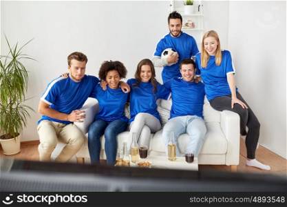 friendship, leisure, sport and entertainment concept - happy friends or football fans with beer watching soccer at home