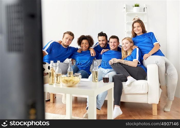 friendship, leisure, sport and entertainment concept - happy friends or football fans with beer watching soccer at home. friends or football fans watching soccer at home