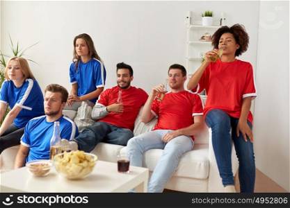 friendship, leisure, sport and entertainment concept - happy friends or football fans drinking beer watching soccer at home. friends or football fans watching soccer at home