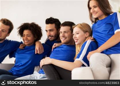 friendship, leisure, sport and entertainment concept - happy friends or football fans watching soccer at home