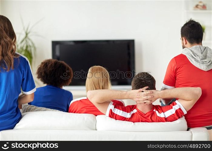 friendship, leisure, sport, people and entertainment concept - happy friends or football fans watching soccer on tv at home