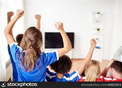 friendship, leisure, sport, people and entertainment concept - happy friends or football fans watching soccer on tv and celebrating victory at home