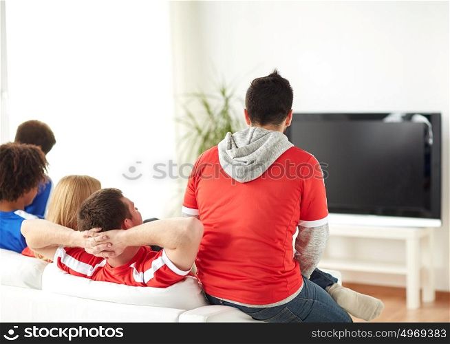 friendship, leisure, sport, people and entertainment concept - happy friends or football fans watching soccer on tv at home. friends or football fans watching tv at home