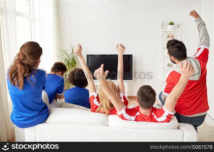 friendship, leisure, sport, people and entertainment concept - happy friends or football fans watching soccer on tv and celebrating victory at home. friends or football fans watching tv at home