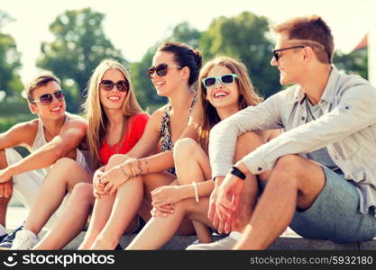 friendship, leisure, summer and people concept - group of smiling friends sitting on city street