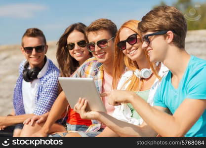 friendship, leisure, summer and people concept - group of smiling friends with tablet pc computer sitting outdoors