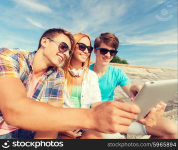 friendship, leisure, summer and people concept - group of smiling friends with tablet pc computers sitting outdoors