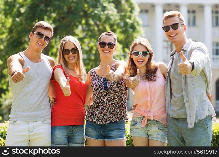friendship, leisure, summer, gesture and people concept - group of smiling friends showing thumbs up outdoors