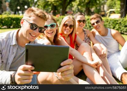 friendship, leisure, summer, technology and people concept - group of smiling friends with tablet pc computer making selfie in park