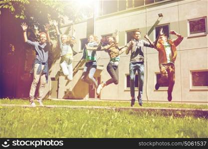 friendship, motion, action, freedom and people concept - group of happy teenage students or friends jumping outdoors. happy teenage students or friends jumping outdoors