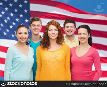 friendship, patriotism and people concept - group of smiling teenagers standing over american flag background