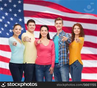 friendship, patriotism and people concept - group of smiling teenagers standing over american flag background