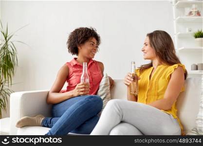 friendship, people and communication concept - happy women with beer talking at home