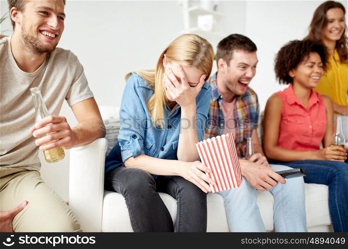 friendship, people and entertainment concept - close up of happy smiling friends with popcorn and beer watching tv at home