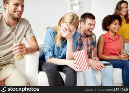 friendship, people and entertainment concept - close up of happy smiling friends with popcorn and beer watching tv at home