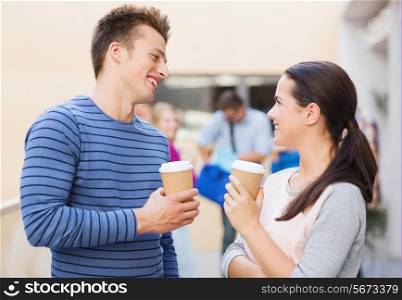friendship, people, drinks and education concept - group of smiling students with paper coffee cups outdoors